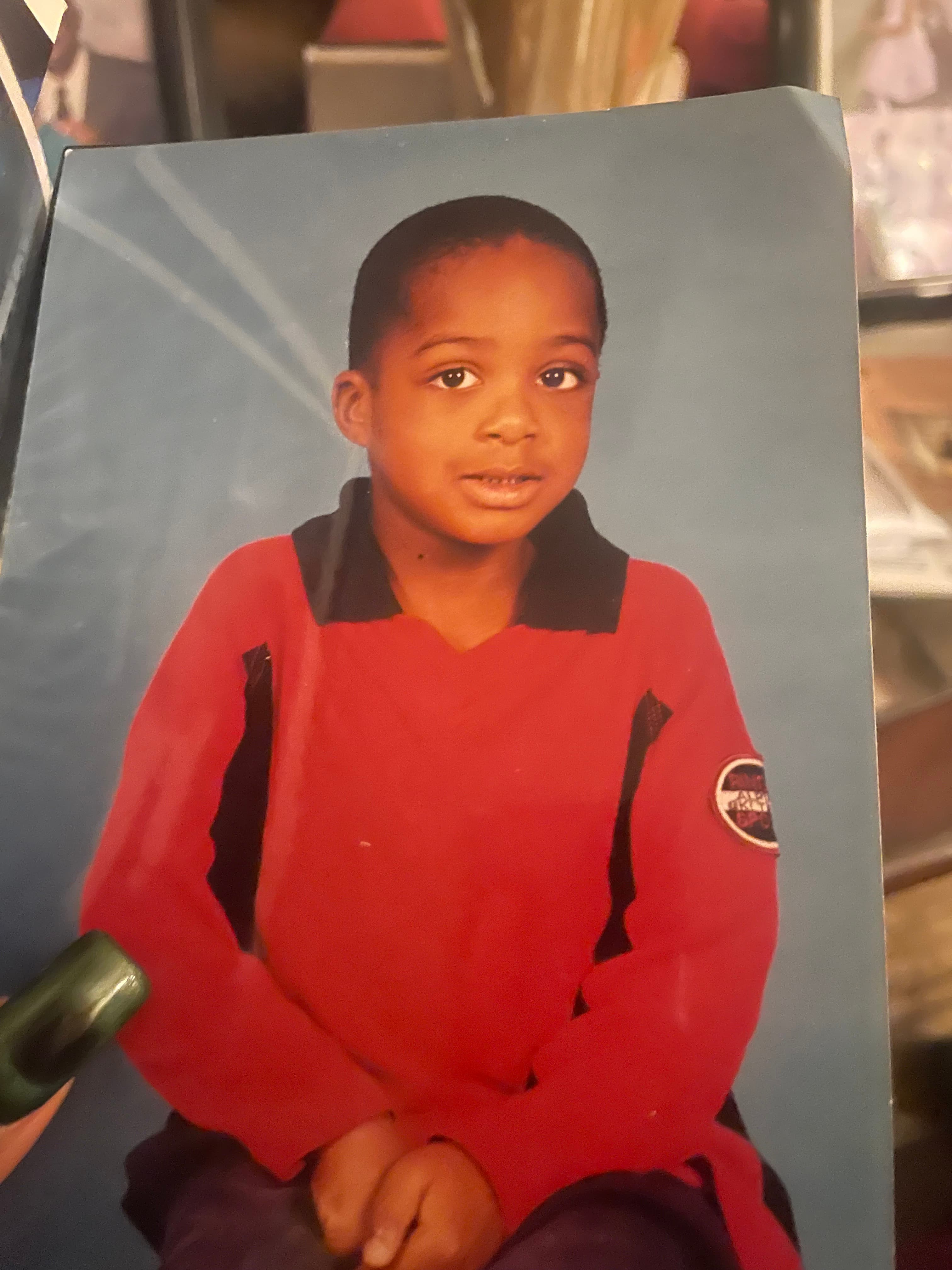 Imagen de referencia de OpenAI: retrato de estudio impreso de un niño con camiseta roja sobre fondo azul