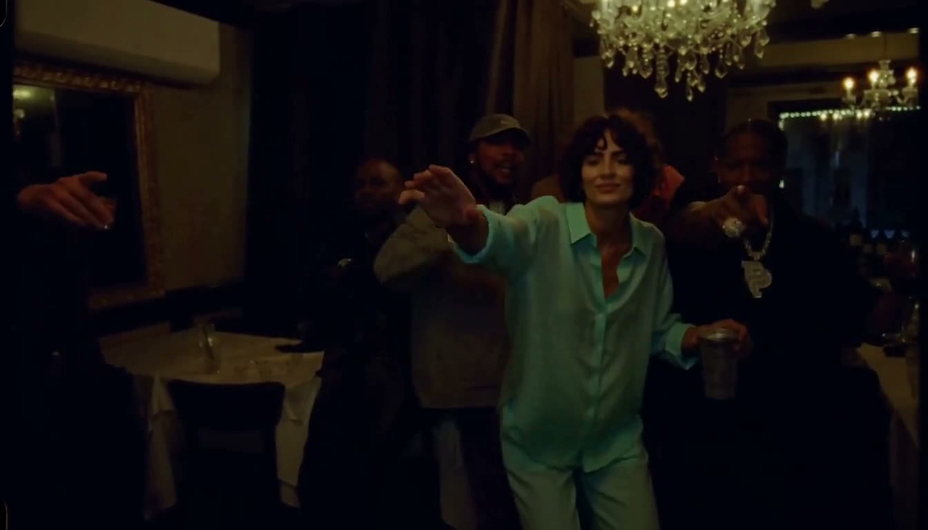 Generated result: the reference character in turquoise clothing performs in the chandelier-lit party scene